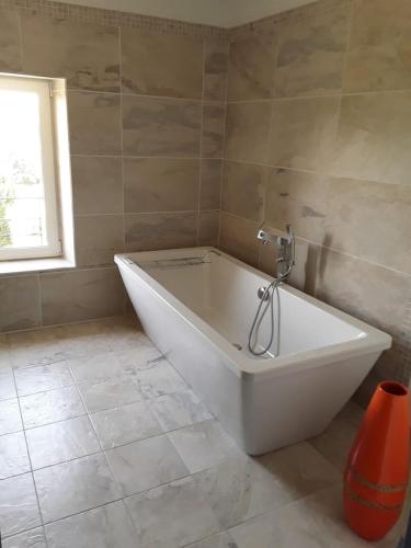 une grande baignoire blanche dans une salle de bain avec une fenêtre dans l'établissement Mas de 