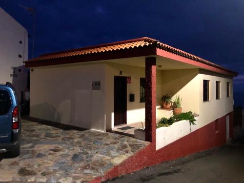 a small house with a car parked in front of it at Vv. Casa La Fuente II in Isora