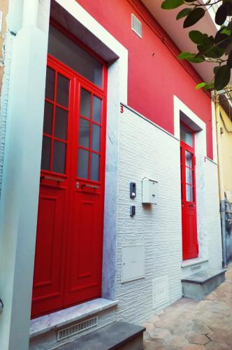 a red door on the side of a building at Hello B&B in Acitrezza