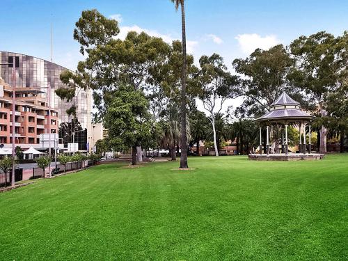 a large green park with a gazebo and trees at Novotel Sydney Parramatta in Sydney