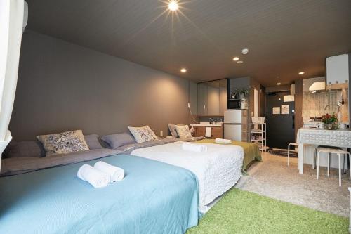 a room with two beds and a couch and a kitchen at Akabane TK Building 102 in Tokyo