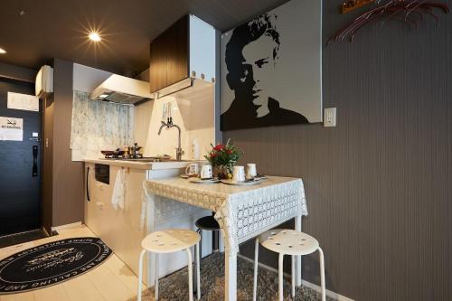 a kitchen with a counter and stools in a room at Akabane TK Building 102 in Tokyo