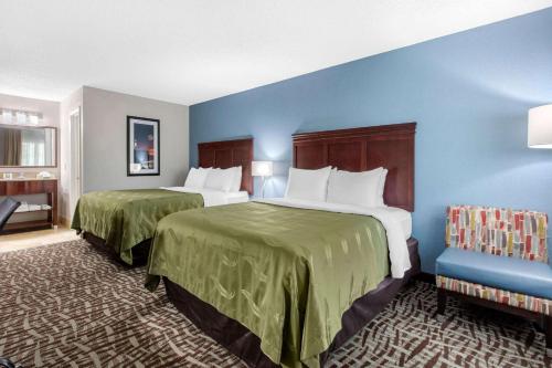 two beds in a hotel room with blue walls at Quality Inn Athens I-65 - Huntsville Area West in Athens