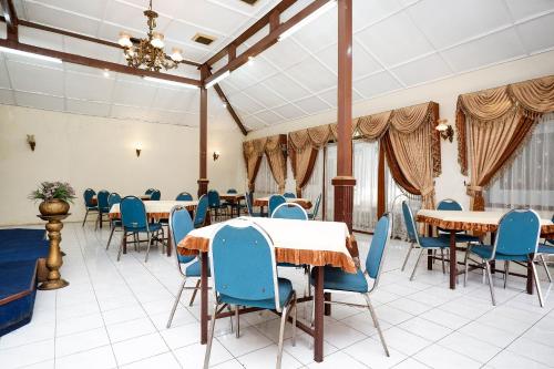 ein Esszimmer mit Tischen und blauen Stühlen in der Unterkunft SUPER OYO Capital O 1644 Hotel Griya Kencana in Solo