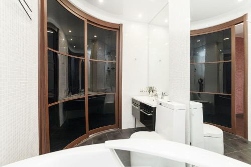 a bathroom with a toilet and a sink and a mirror at Aparthotel Daudel Tyumen Center in Tyumen