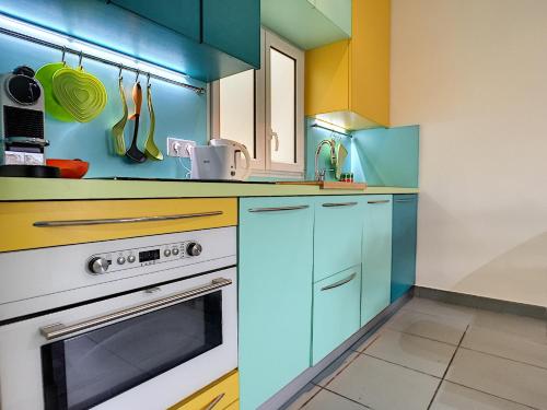 une cuisine avec des armoires bleues et jaunes et une cuisinière dans l'établissement Nestor&Jeeves - POP RETRO - Central - By sea, à Nice