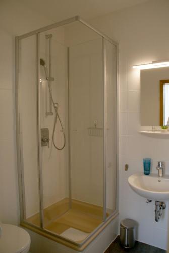 a bathroom with a shower and a sink at Romagna Mia - Hotel Ristorante Pizzeria in Nersingen