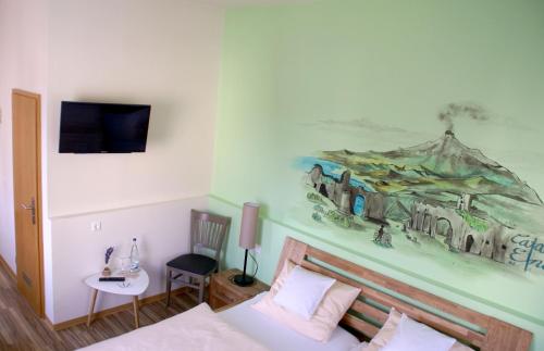 1 dormitorio con 1 cama y una pintura en la pared en Romagna Mia - Hotel Ristorante Pizzeria, en Nersingen