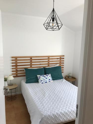 a bedroom with a white bed with green pillows at BonitaBay in São Martinho do Porto