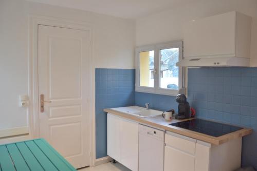 a small kitchen with a sink and blue tiles at Tiny Bikini, Ault, Baie de Somme, 200 m de la mer in Ault