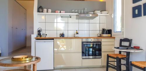 a small kitchen with a white tiled wall at BanSala Villas in Vounaria