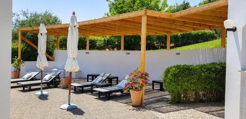 a patio with umbrellas and chairs under a pavilion at BanSala Villas in Vounaria