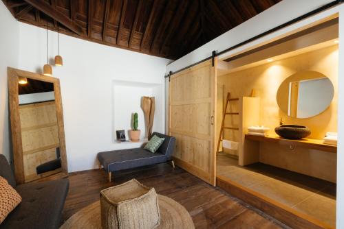 a living room with a couch and a mirror at Hotel Boutique Palacio Ico - Only Adults in Teguise