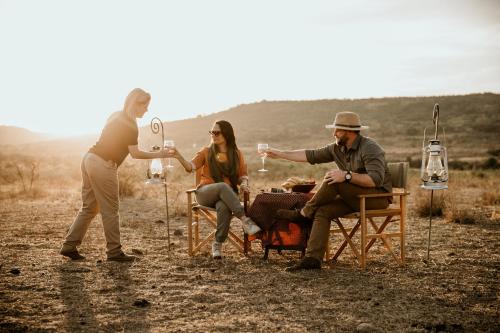 a group of people sitting around a table with wine glasses at Nambiti Hills in Nambiti Private Game Reserve