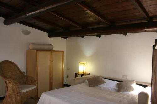 a bedroom with a white bed and a chair at Casa Stella Di Madel in Flumini di Quartu