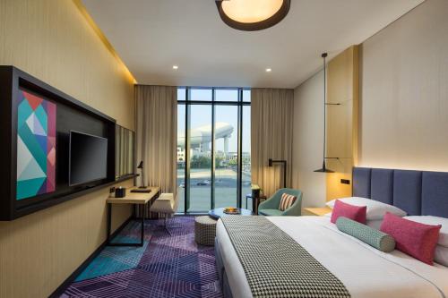 a hotel room with a bed and a television at Millennium Al Barsha in Dubai