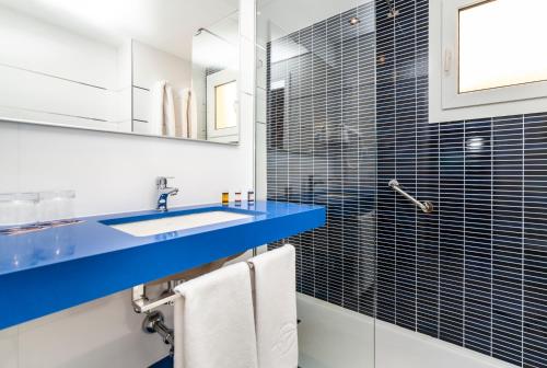 y baño con lavabo azul y ducha. en Globales Binimar, en Cala en Blanes