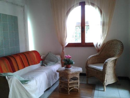 a bedroom with a bed and a chair and a window at Casa Stella Di Madel in Flumini di Quartu