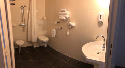 a bathroom with a toilet and a sink at Hôtel Inn Design Resto Novo Le Mans in Arnage