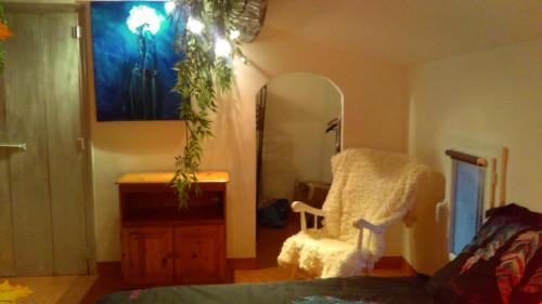 a living room with a chair and a mirror at Bien-être in Alignan-du-Vent