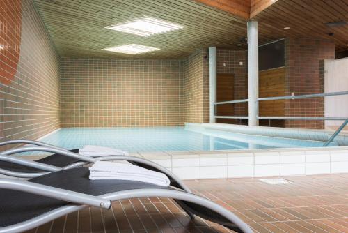 a swimming pool in a building with a swimming pool at Hotel Kreuz Lenk in Lenk