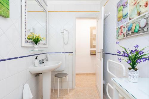 Un baño blanco con lavabo y espejo. en Vivienda Vacacional La Laguna Deluxe 1, en La Laguna