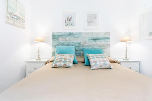 Un dormitorio con una cama grande con almohadas azules. en Vivienda Vacacional La Laguna Deluxe 1, en La Laguna