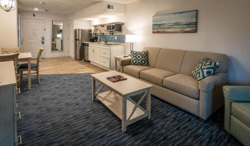 a living room with a couch and a table at Palmera Inn and Suites in Hilton Head Island