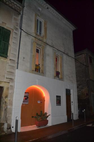 a building with an orange door in front of it at Bien-être in Alignan-du-Vent
