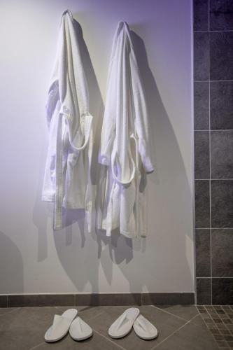 - un mur avec 2 serviettes et 2 paires de chaussons dans l'établissement Le Sensuel, à Isigny-sur-Mer