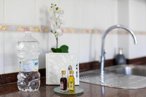 a bottle of water and two bottles of alcohol on a kitchen counter at Vivienda Vacacional La Laguna Deluxe 2 in Las Lagunas