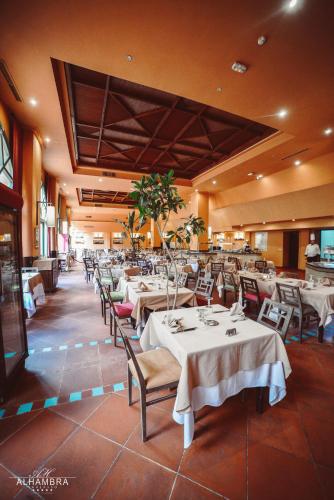 a dining room with tables and chairs in a restaurant at Alhambra Thalasso in Hammamet