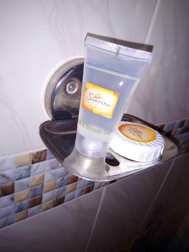a bathroom sink with a bottle of soap and a candle at Sunview Lodge & Restaurant in Libwezi