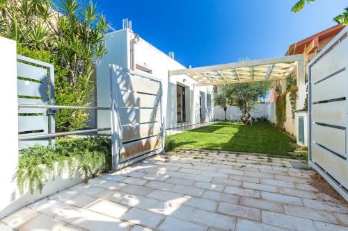 a walkway leading to a yard with a pergola at Alexander B&B in Tortolì