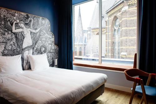 a bedroom with a bed and a large window at Hotel Mariënhage in Eindhoven