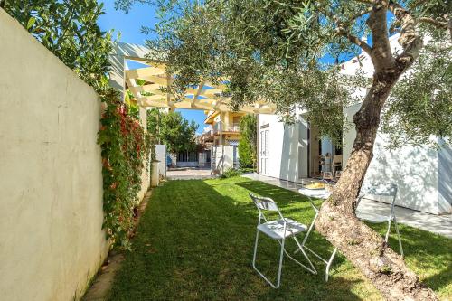 a yard with two chairs and a tree at Alexander B&B in Tortolì
