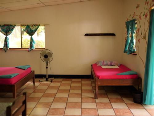 a room with two beds and a window at Hospedaje Soma in Moyogalpa