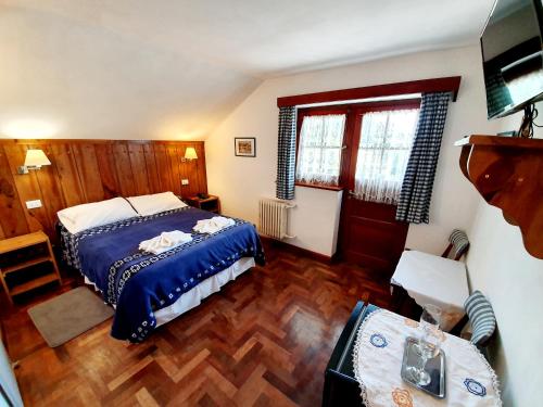a bedroom with a bed and a chair in it at Hotel La Cumbrecita in La Cumbrecita