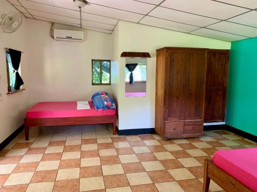 a room with two beds and a cabinet at Hospedaje Soma in Moyogalpa