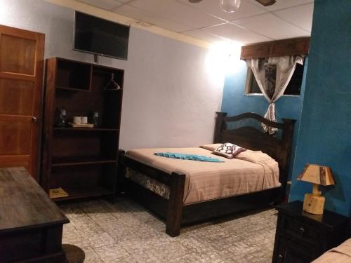 a bedroom with a bed and a blue wall at Hospedaje El Viajero in Panajachel