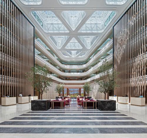 a rendering of a lobby with tables and chairs at JA The Resort - JA Lake View Hotel in Dubai