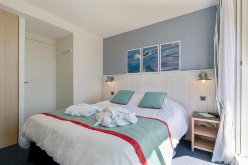 a bedroom with a bed with towels on it at Résidence Pierre & Vacances Premium Le Domaine de Cramphore in Le Pouliguen