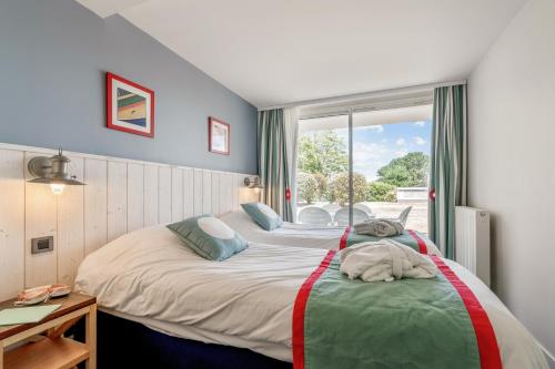 A bed or beds in a room at Résidence Pierre & Vacances Premium Le Domaine de Cramphore