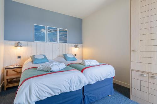 a bedroom with two beds with towels on them at Résidence Pierre & Vacances Premium Le Domaine de Cramphore in Le Pouliguen