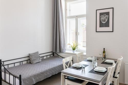 ein Wohnzimmer mit einem Bett, einem Tisch und einem Fenster in der Unterkunft Penzion Apartmány Hradební in Uherské Hradiště