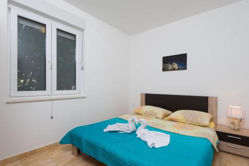 1 dormitorio con 2 toallas en una cama en Apartments Leko, en Orebić