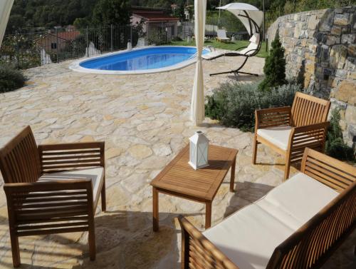 eine Terrasse mit Stühlen, einem Tisch und einem Pool in der Unterkunft CASA AZZURRA in Imperia