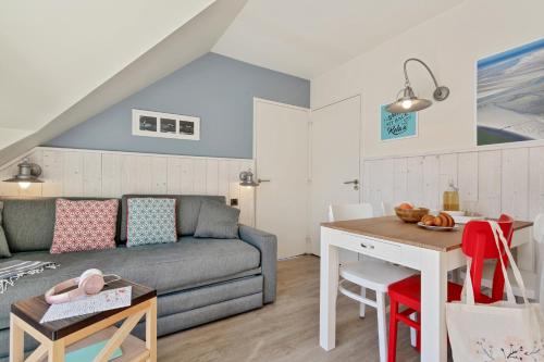 a living room with a couch and a table at Résidence Pierre & Vacances Premium Le Domaine de Cramphore in Le Pouliguen