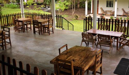 an outdoor patio with wooden tables and chairs at Hospedaje Soma Ometepe Hotel in Moyogalpa