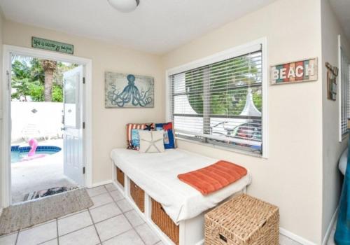 a small bedroom with a bed and a window at Bianco Sands Resort by Beachside Management in Siesta Key